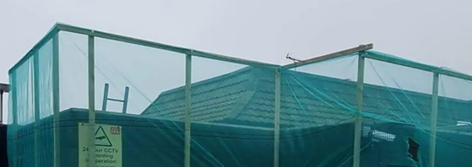 Commercial job: a tiled hip roof inside scaffold and safety netting