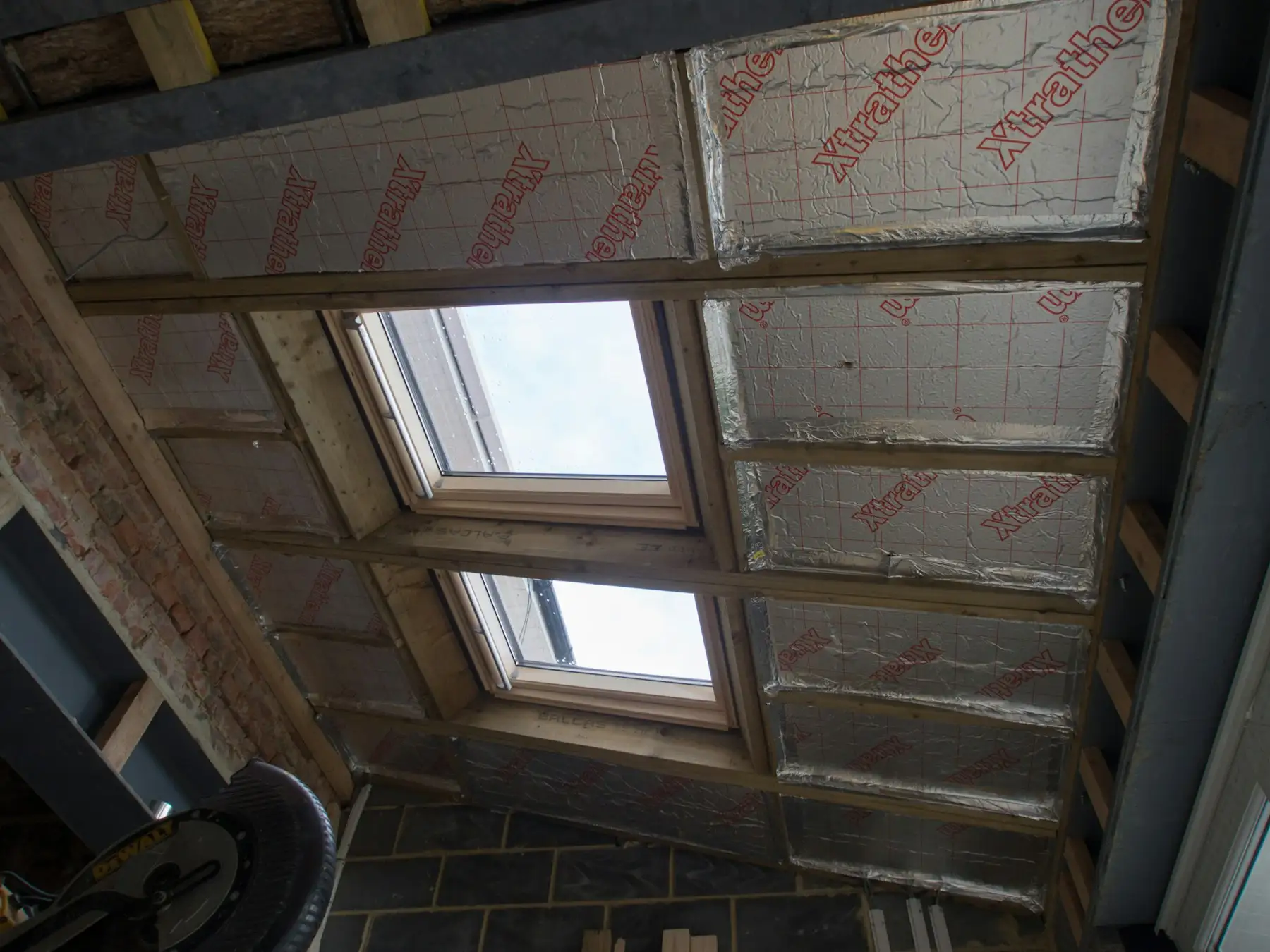 Insulation boards fitted between roof rafters, with two roof windows
