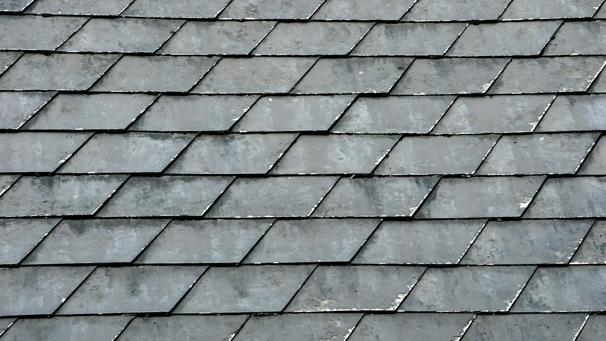 Close view of dark grey slates laid in even courses