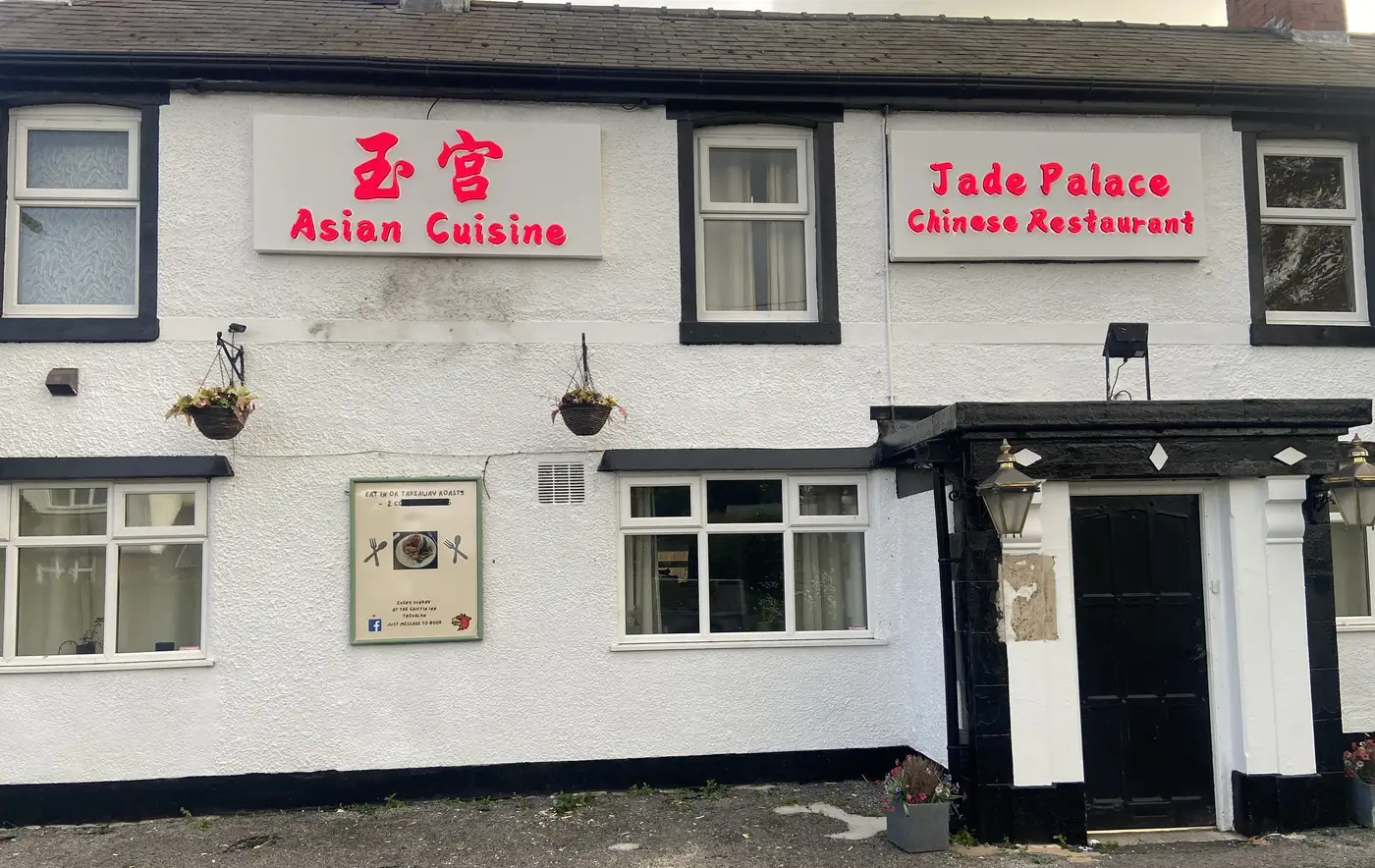 The white-painted Griffin Inn with black trim, now carrying two red signs: 玉宮 Asian Cuisine, and Jade Palace Chinese Restaurant.