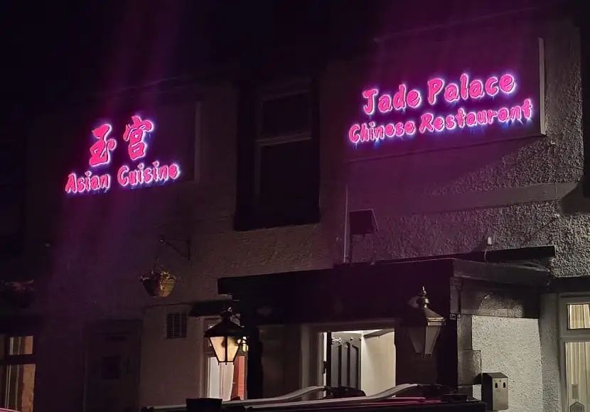 The Jade Palace signs lit up red after dark, above the pub’s porch lanterns.