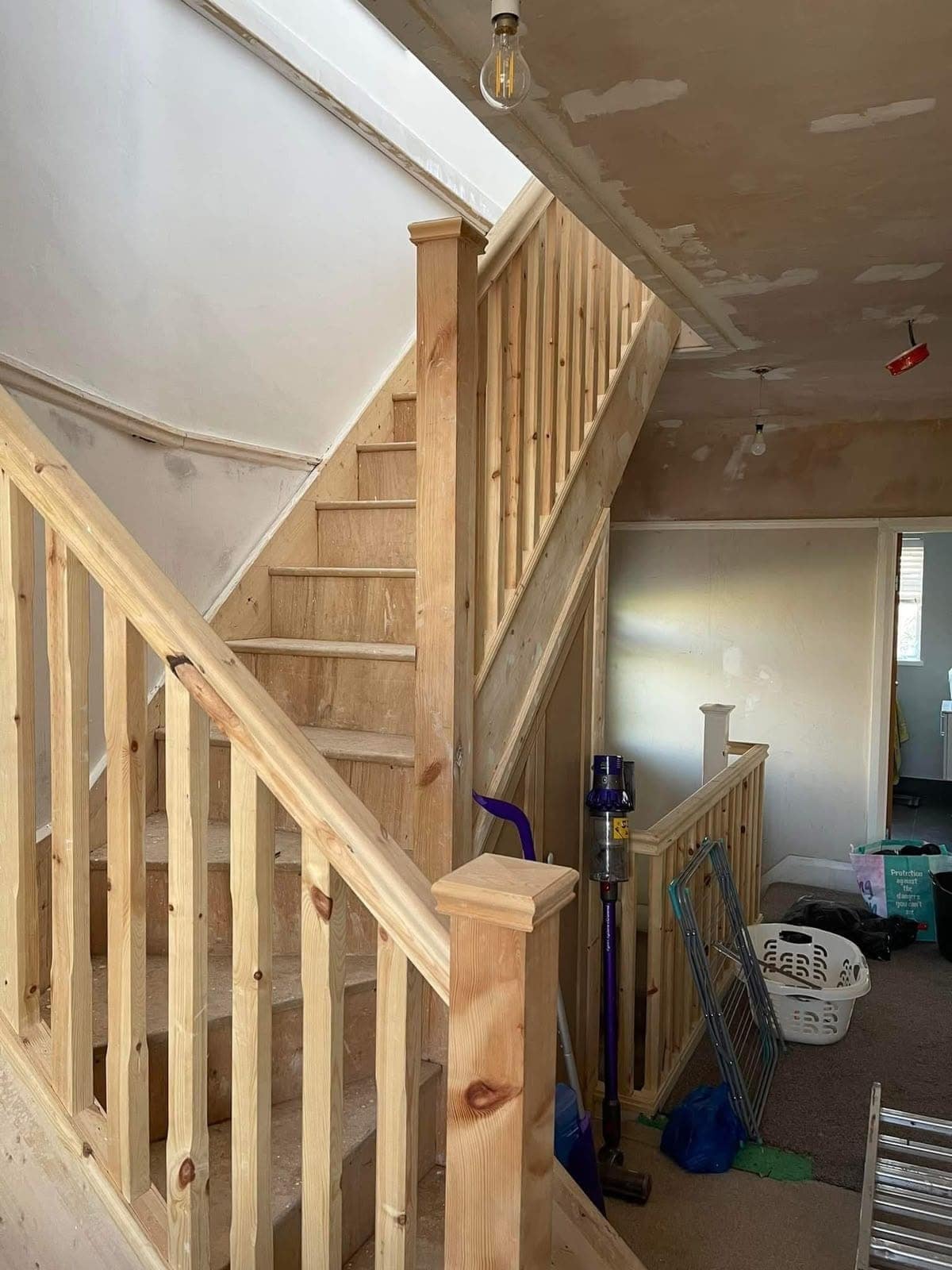 The staircase in bare pine, knots unsealed, before any paint