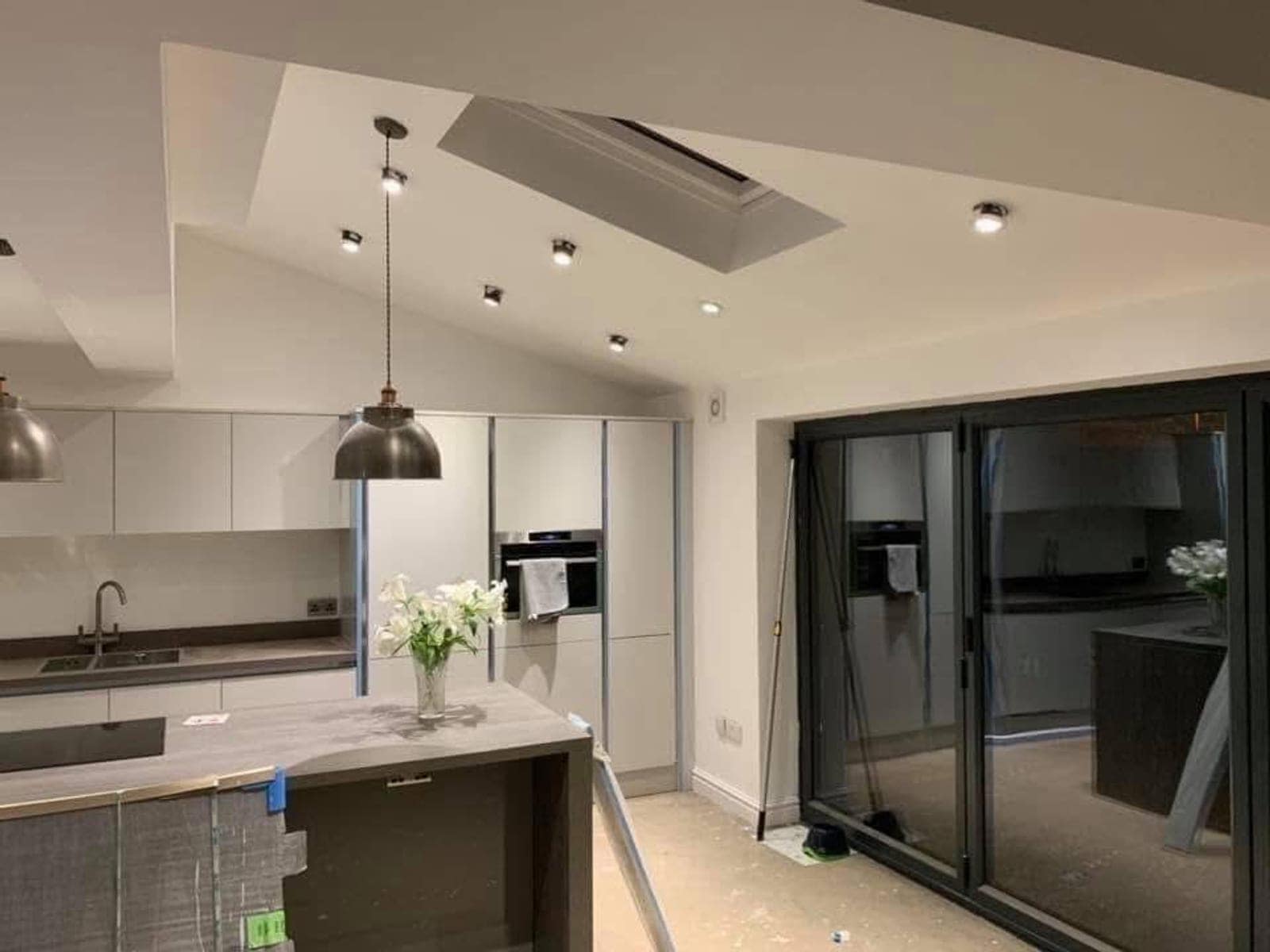 Open-plan kitchen with a vaulted ceiling, roof light and bifold doors, decorated around the fitted units